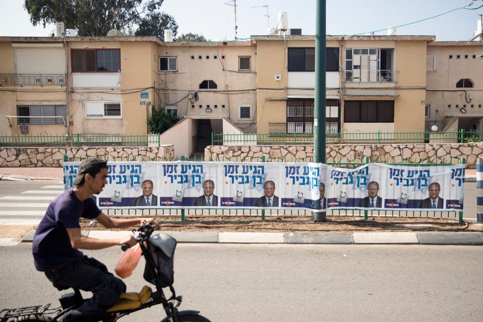 A man rides by a 'Jewish Zionist' party campaign poster showing party member Itamar Ben-Gvir on Oct. 27 in Or Akiva, Israel. Israelis return to the polls on Nov. 1 for a fifth general election in four years.<span class="copyright">Amir Levy—Getty Images</span>