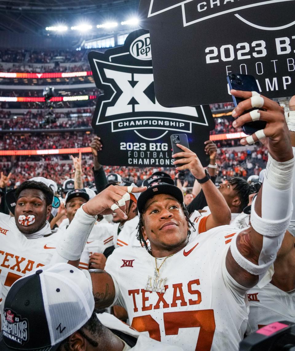 Texas linebacker Morice Blackwell Jr. celebrates with the team after winning the Big 12 championship game 49-21 over Oklahoma State at AT&T Stadium in Arlington on Saturday.