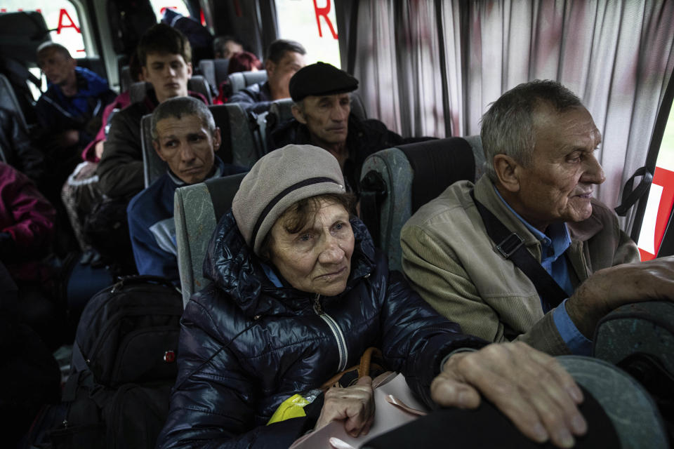 People sit in a bus during evacuation from Lyman, Donetsk region, eastern Ukraine, Saturday, April 30, 2022. (AP Photo/Evgeniy Maloletka)