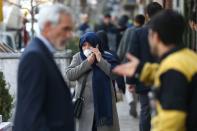 An Iranian woman wears a protective face mask, following the coronavirus outbreak, as she talks on the phone, in Tehran