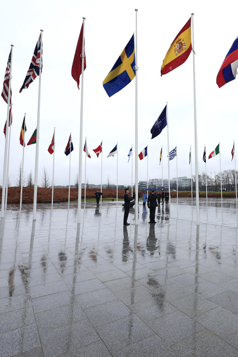 Members of the military raise the flag of Sweden, as other other alliance member flags flap in the wind, during a ceremony to mark the accession of Sweden to NATO at NATO headquarters in Brussels, Monday, March 11, 2024. (AP Photo/Geert Vanden Wijngaert)