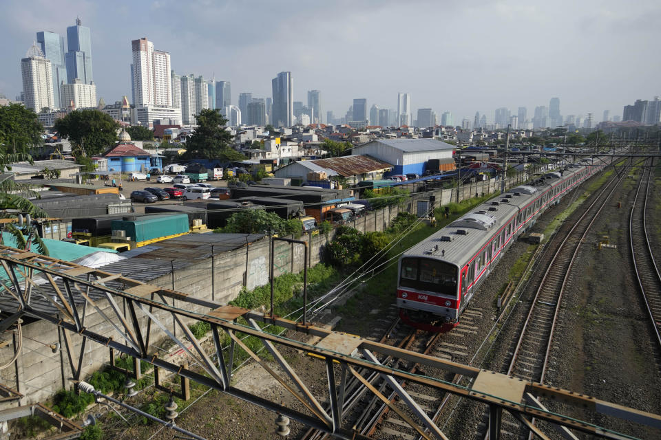 A train runs on its track as the city skyline is seen in the background in Jakarta, Indonesia, Monday, Feb. 12, 2024. Indonesia, the world's third-largest democracy, will open its polls on Wednesday to nearly 205 million eligible voters in presidential and legislative elections, the fifth since Southeast Asia's largest economy began democratic reforms in 1998. (AP Photo/Achmad Ibrahim)