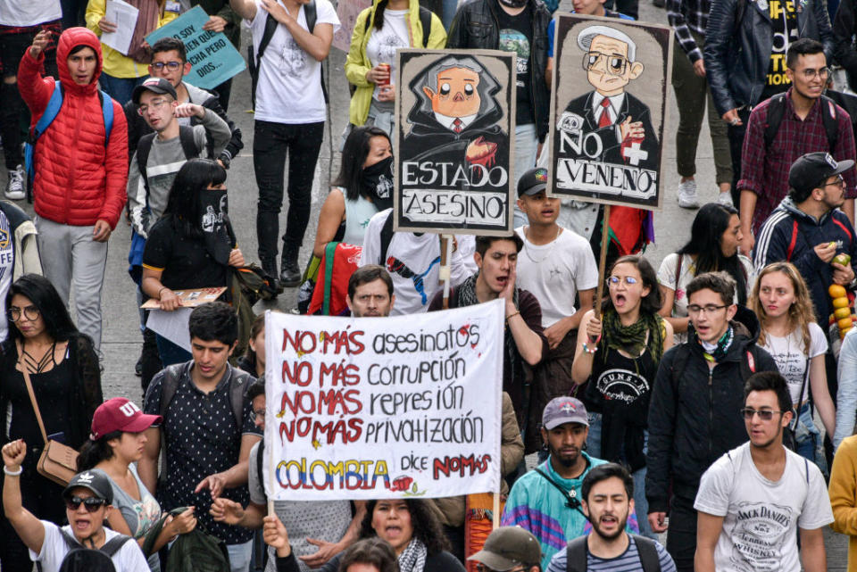 Anti-government demonstrators march holding sign calling for no more assassinations, corruption, repression and privatization Nov. 21, 2019 in Bogota, Colombia. | Guillermo Legaria Schweizer/Getty Images