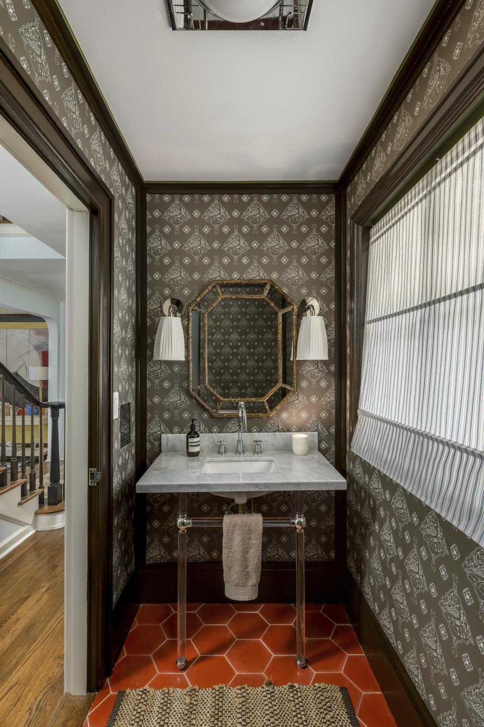 This image provided by Daniel House Club shows a powder room designed by Peter Spalding of Daniel House Club. It features Katie Ridder's Oiseau wallpaper, Hex's barn-hued tile, Behr's Espresso Beans paint, contemporary lighting and a sleek marble sink. Spalding says "slow decorating" includes buying the most authentic versions of furniture that you can afford. (Kelly Kish Photography via AP)