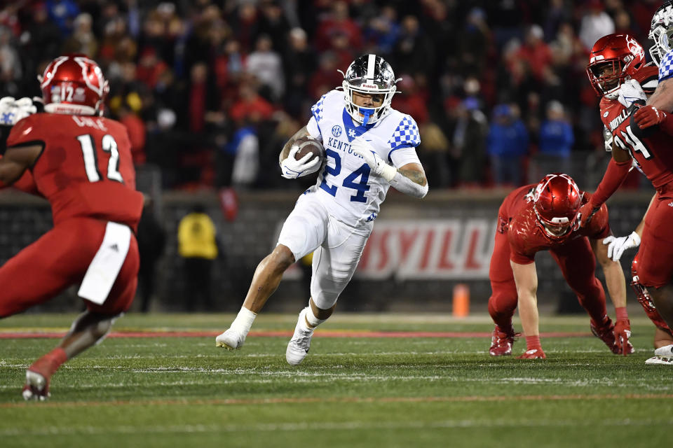 Kentucky running back Chris Rodriguez Jr. (24) runs through an opening in the Louisville line during the first half of an NCAA college football game in Louisville, Ky., Saturday, Nov. 27, 2021. (AP Photo/Timothy D. Easley)