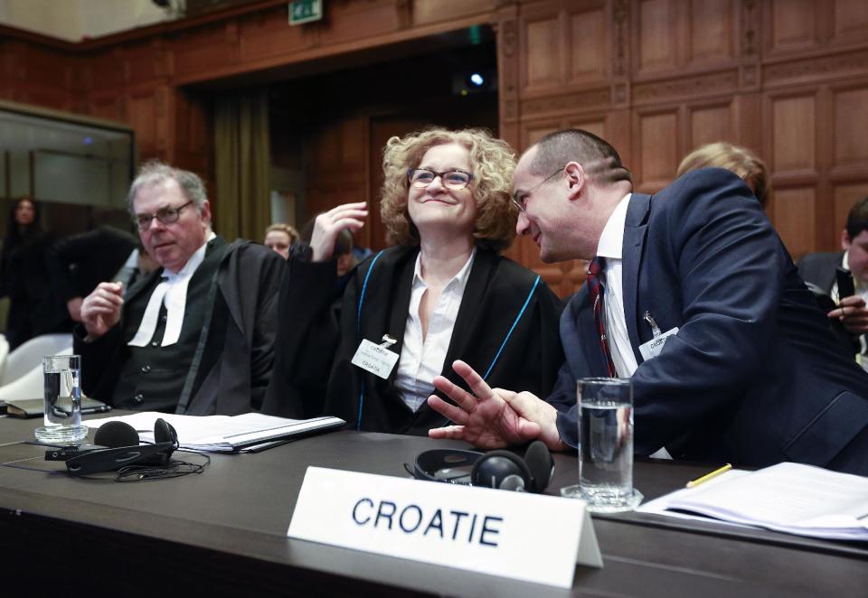 Members of the Croatian delegation, Minister Orsat Miljenic, right, Vesna Crnic-Grotic, center, and James Crawford, left, await the start of public hearings at the International Court of Justice (ICJ) in The Hague, Netherlands, Monday, March 3, 2014. Croatia is accusing Serbia of genocide during fighting in the early 1990's as the former Yugoslavia shattered in spasms of ethnic violence, in a case at the United Nations' highest court that highlights lingering animosity in the region. Croatia is asking the ICJ to declare that Serbia breached the 1948 Genocide Convention when forces from the former Federal Republic of Yugoslavia attempted to drive Croats out of large swaths of the country after Zagreb declared independence in 1991. (AP Photo/Jiri Buller)