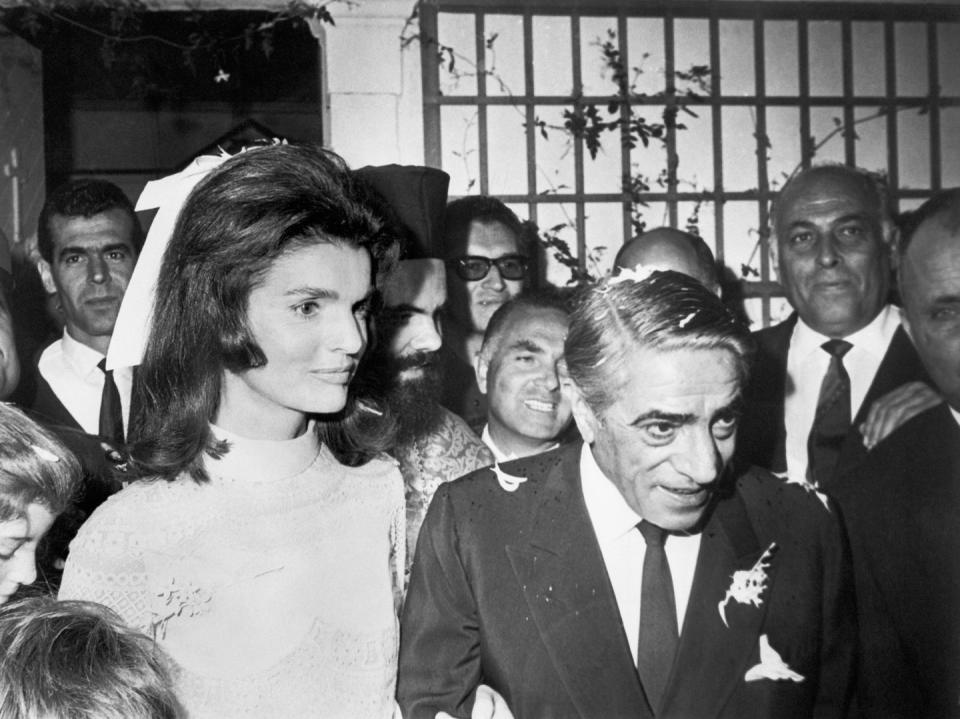 <p>The former First Lady marries her second husband, Aristotle Onassis, on his private island Skorpios, located off the coast of Greece. Jackie wore a knee-length ivory lace dress designed by Valentino and a white ribbon in her hair.<br></p>