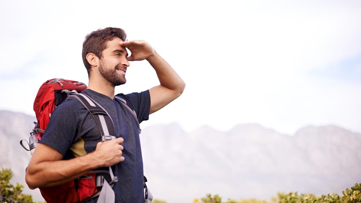  Shot of a man enjoying a hike on a sunny day. 