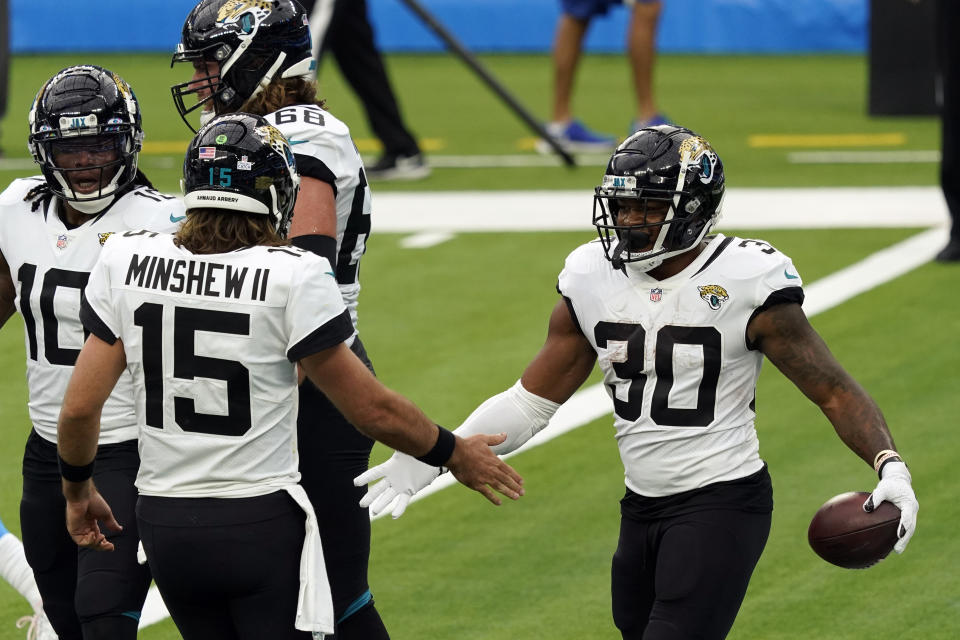 Jacksonville Jaguars running back James Robinson, right, celebrates his rushing touchdown with Gardner Minshew (15) during the first half of an NFL football game against the Los Angeles Chargers Sunday, Oct. 25, 2020, in Inglewood, Calif. (AP Photo/Alex Gallardo )