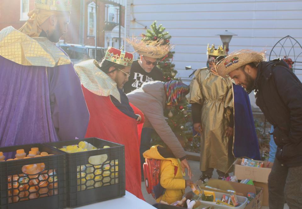 Today, books, snacks and drinks were handed out by the three kings who set up across the street from Harding Elementary. Pictured here is Ra'siah, son of Jenita Baker, picking out a toy.