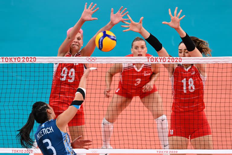 La argentina Paula Nizetich golpea el balón frente a las turcas Ebrar Karakurt y Zehra Gunes en el partido de voleibol femenino de la ronda preliminar del grupo B entre Argentina y Turquía.