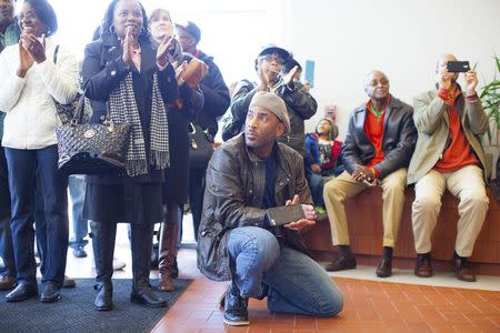 Matt Talford (kneeling), a resident of Rock Hill, watches court proceedings with others as a group of black civil rights protesters nicknamed the "Friendship Nine" appear at a courthouse to have their trespassing convictions vacated, in Rock Hill, South Carolina January 28, 2015. REUTERS/Jason Miczek