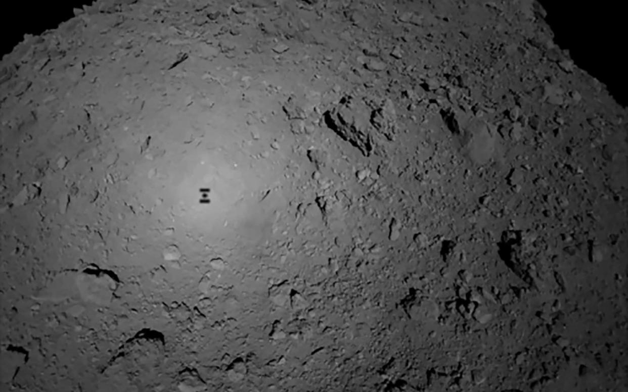 The shadow of the Japanese spacecraft Hayabusa2 (L) is seen over the asteroid Ryugu - AFP