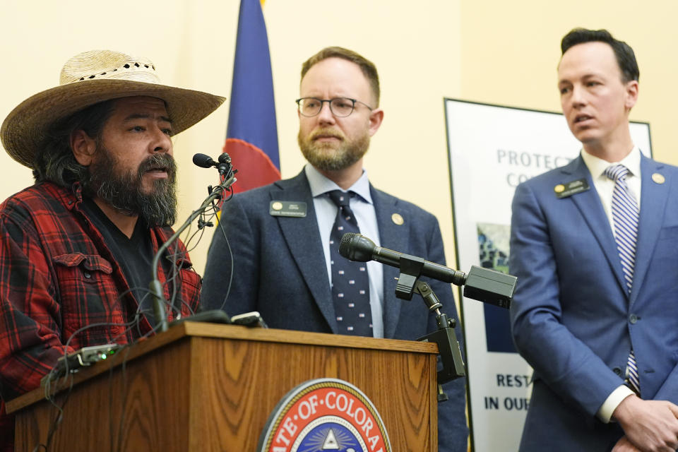 From left, George Rosales of Denver speaks as Colorado State Representative Matt Soper, R-Delta, and State Sen. Dhylan Roberts, D-Eagle, listen during a news conference to unveil bipartisan legislation to license funeral home professionals in Colorado Monday, March 4, 2024, the State Capitol in Denver. (AP Photo/David Zalubowski)