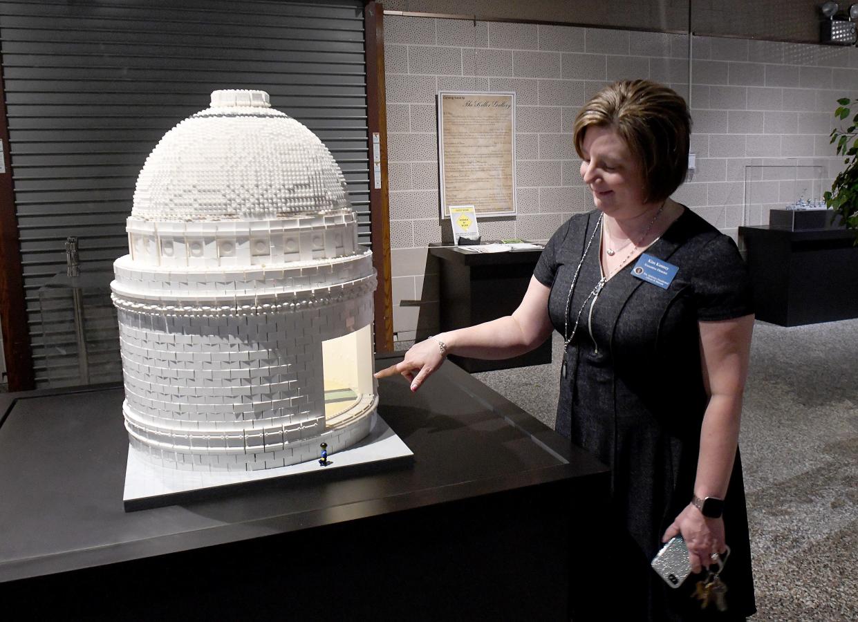 Kimberly Kenney, executive director of the McKinley Presidential Library & Museum, is shown with a replica McKinley National Memorial constructed from Legos. The model is part of the new exhibit, "Brick Flicks" by artist Warren Elsmore, which features iconic scenes from 40 movies constructed from Lego bricks.