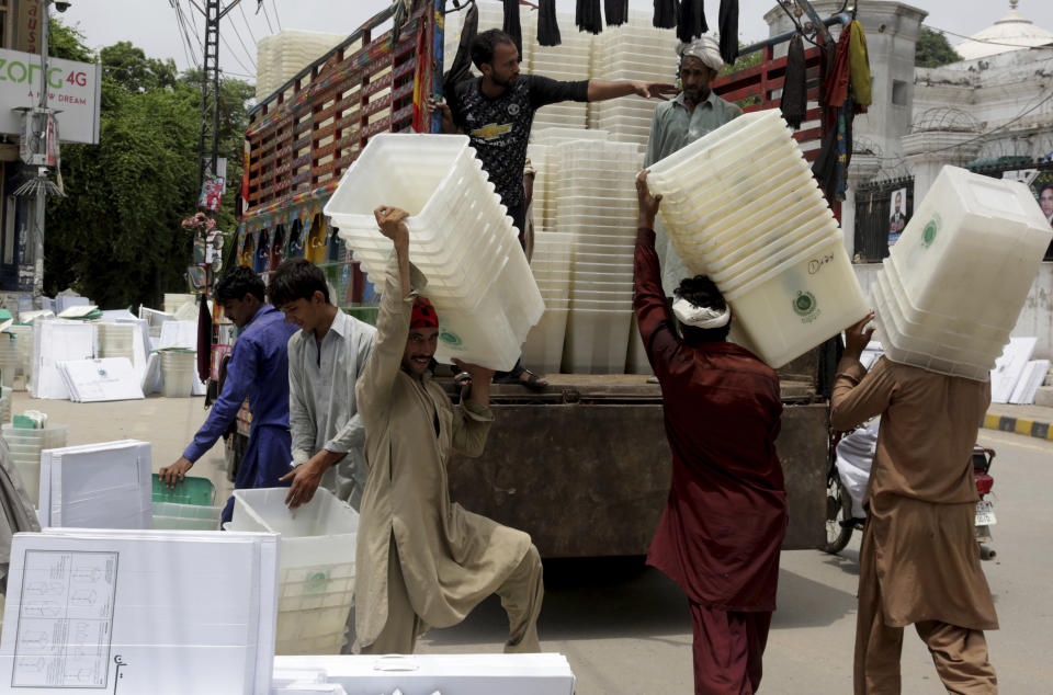 Workers collect ballot boxes and polling material after polling in Lahore, Pakistan, Thursday, July 26, 2018. The suicide attack outside the polling station in Quetta which killed dozens of people, underscored the difficulties the majority Muslim nation faces on its wobbly journey toward sustained democracy. (AP Photo/K.M. Chaudary)