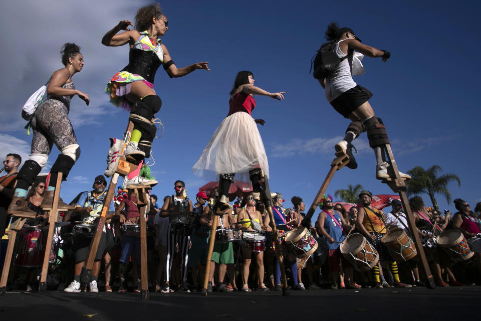 FILE - Revelers parade on wooden stilts during a pre-Carnival street party rehearsal, in Rio de Janeiro, Brazil, Jan. 21, 2024. A boom in stilt walking has altered the landscape of the world’s biggest Carnival, where hundreds of stilt walkers tower over the many raucous parties that occupy and dominate public areas. (AP Photo/Bruna Prado, File)