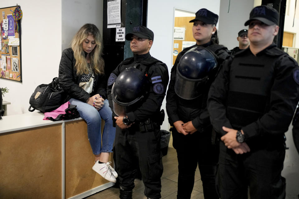 La empleada pública Florencia Ugarte sentada, mientras la policía impide que sus compañeros despedidos ingresen al Instituto Nacional contra la Discriminación, la Xenofobia y el Racismo (INADI) en Buenos Aires, Argentina, el miércoles 3 de abril de 2024. En sus cuatro primeros meses al poder, el presidente ultraliberal Javier Milei ha degradado el Ministerio de Mujeres, Géneros y Diversidad al rango de subsecretaría, prohibido el uso del lenguaje inclusivo en la administración pública y cerrado el INADI. (AP Foto/Natacha Pisarenko)