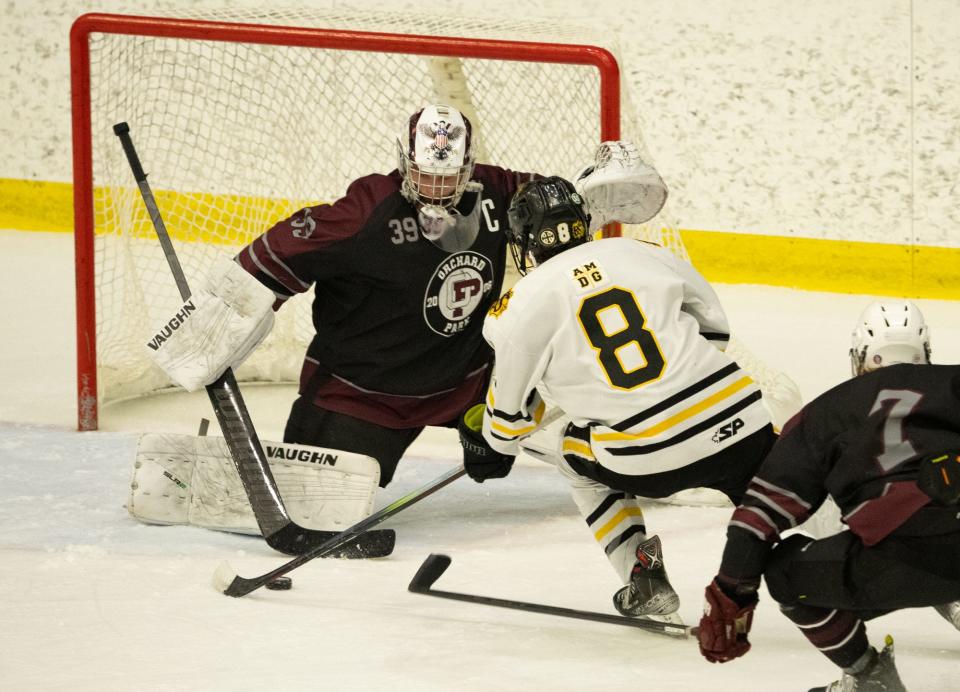 McQuaid's Jack Callery crashes the net on Orchard Park goalie Brayden Hearn.