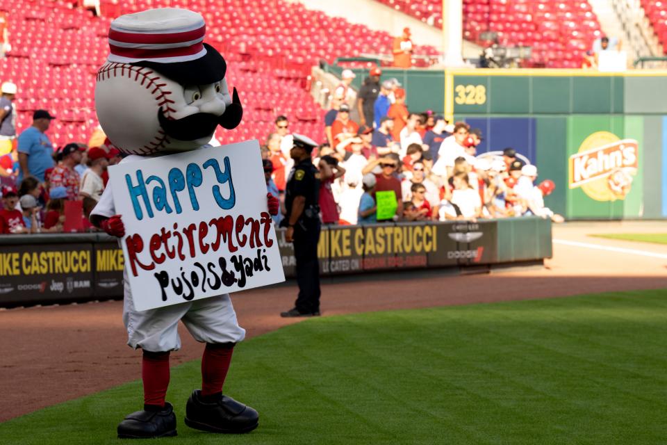 Mr. Redlegs holds a sign offering St. Louis Cardinals first baseman Albert Pujols (5) a happy retirement before the MLB game between between the Cincinnati Reds and the St. Louis Cardinals at Great American Ball Park in Cincinnati, Wednesday, Aug. 31, 2022.