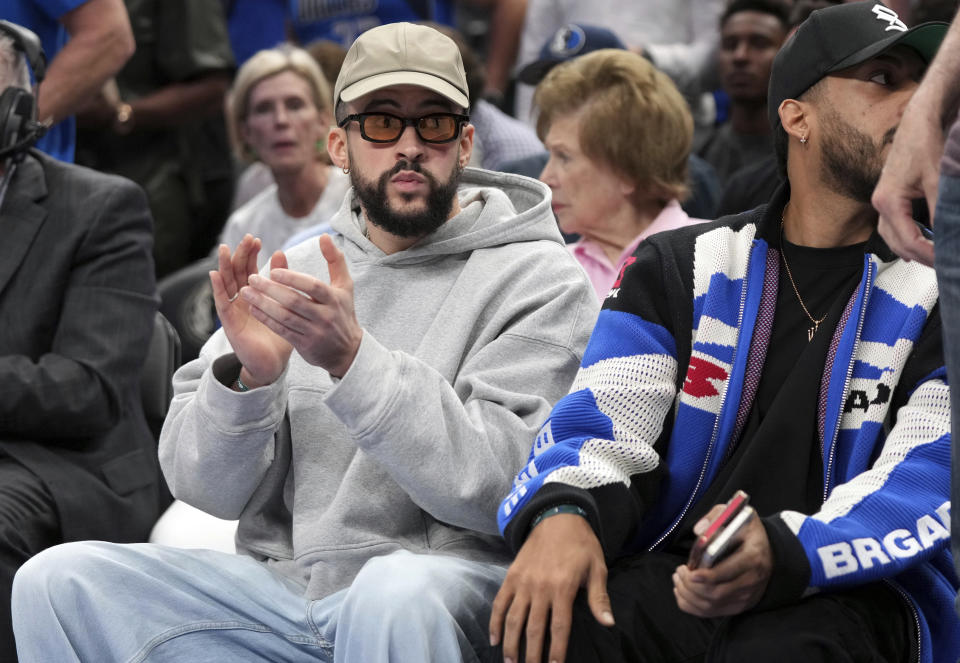 FILE - Puerto Rican recording artist Bad Bunny claps sitting court side during an NBA basketball playoff game between the Dallas Mavericks and the Los Angeles Clippers, in Dallas, April 28, 2024. Puerto Rico's professional basketball league is experiencing a renaissance thanks to reggaeton stars like Bad Bunny, Ozuna and Anuel AA, who are stepping into the financial game, buying local teams and helping to stack up a loyal fan base. (AP Photo/Jeffrey McWhorter, File)