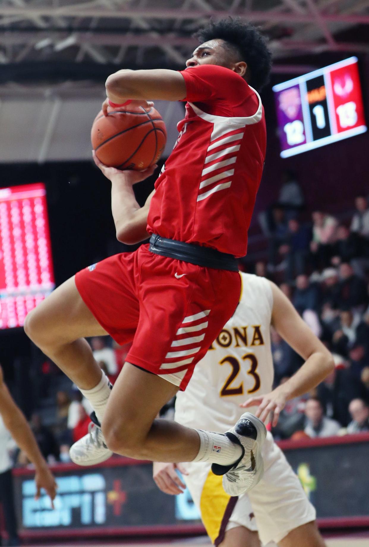 Marist's Jadin Collins (0) goes up for a shot in front of Iona's Dylan Saunders (23) during NCAA basketball action at Hynes Center at Iona University in New Rochelle Nov. 29, 2023.