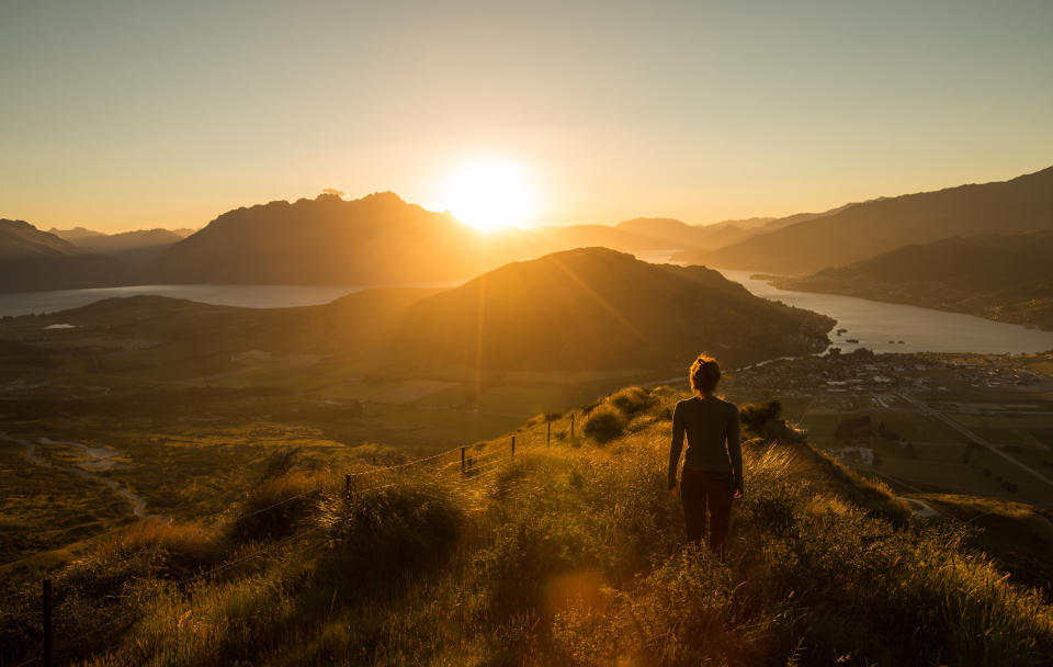 A woman's silhouette at sunset on a mountain.