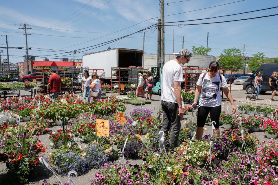 People walking through the flower garden to grab flowers at the Juneteenth Fest at the Eastern Market in Detroit on Sunday, June 19, 2022. 