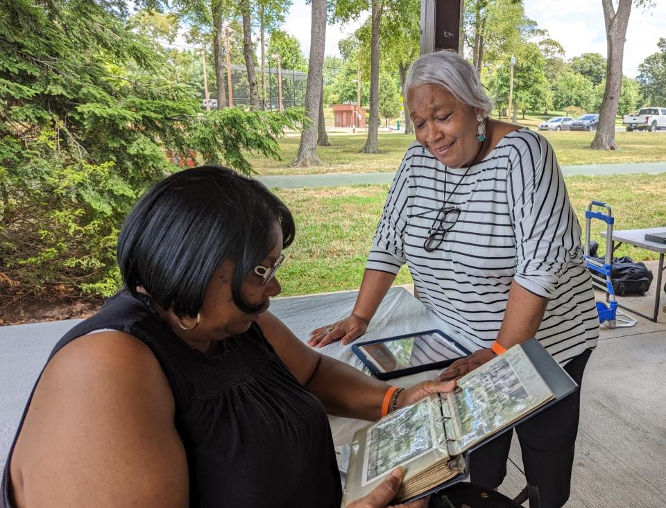 Marcella Lewis and Wanda Stokes look over photo albums during the summer reunion of the former residents of Lafayette Street SE in Canton. The street was wiped out in the early 1970s for an urban renewal project.