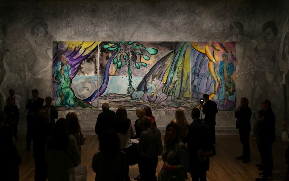 Visitors view the British artist Chris Ofili's tapestry 'The Caged Bird's Song' at the 'Weaving Magic' exhibition at the National Gallery in April - AFP