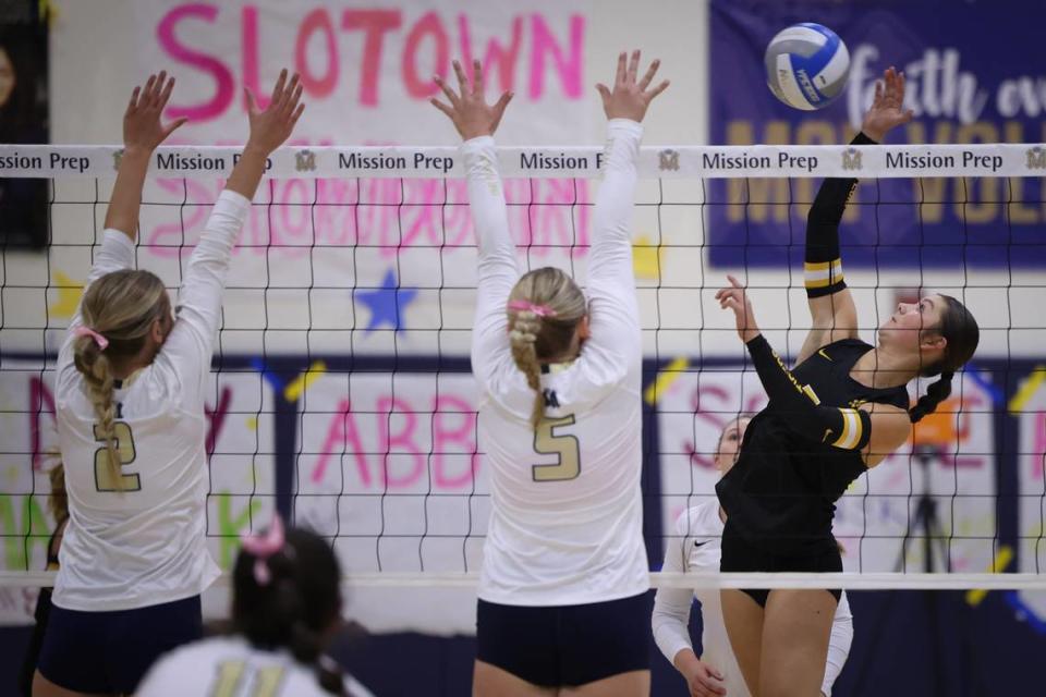 Alina Ashby hits as Abby Ozmina (2) and Dani Swendenborg (5) defend. Cowitz Gymnasium at Mission Prep was full and loud as the San Luis Obispo Tigers girls volleyball team beat the Royals 3-0 Sept. 26, 2023.