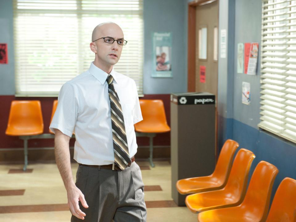 Jim Rash as Dean Pelton walking down a hallway in "Community."