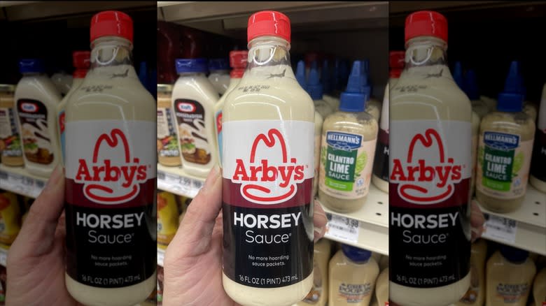 Holding bottle of Horsey Sauce