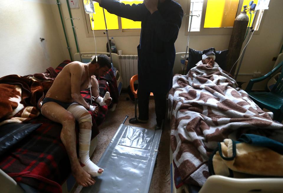 In this picture taken on Wednesday, March 5, 2014, Ibrahim, right, and Adul-Karim, left, both18, Syrian rebels who were injured during a battle against government forces and Hezbollah fighters in Rima village near Yabroud, the last rebel stronghold in Syria's mountainous Qalamoun region, lie on their beds at a makeshift hospital where they receive medical treatments, in the Lebanese-Syrian border town of Arsal, eastern Lebanon. Trucks of armed fighters rumble from this Lebanese Sunni town through the mountains to the front in Syria, where rebels are in a furious fight to keep a vital stronghold. At the same time, Lebanese Shiite fighters from a town not far away are also streaming in to join the battle _ but on the opposing side, backing Syrian government forces. The battle has effectively erased the border between the two countries and underlines how dangerously Lebanon is being sucked into its neighbor’s civil war. (AP Photo/Hussein Malla)