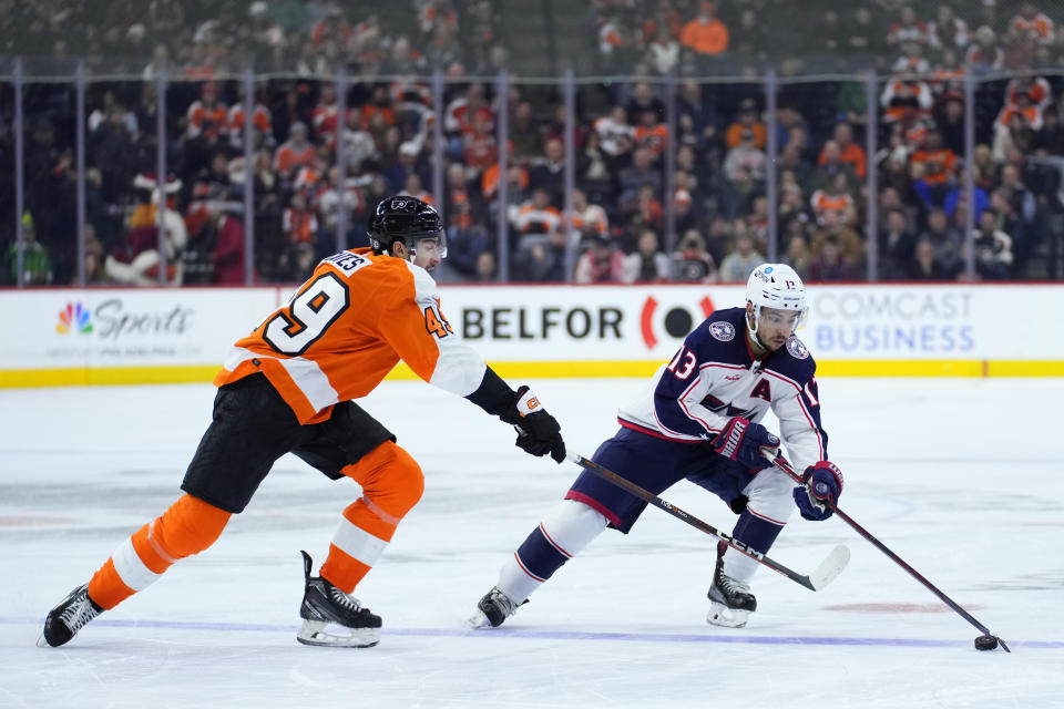 Columbus Blue Jackets' Johnny Gaudreau, right, tries to get past Philadelphia Flyers' Noah Cates during the third period of an NHL hockey game, Tuesday, Dec. 20, 2022, in Philadelphia. (AP Photo/Matt Slocum)