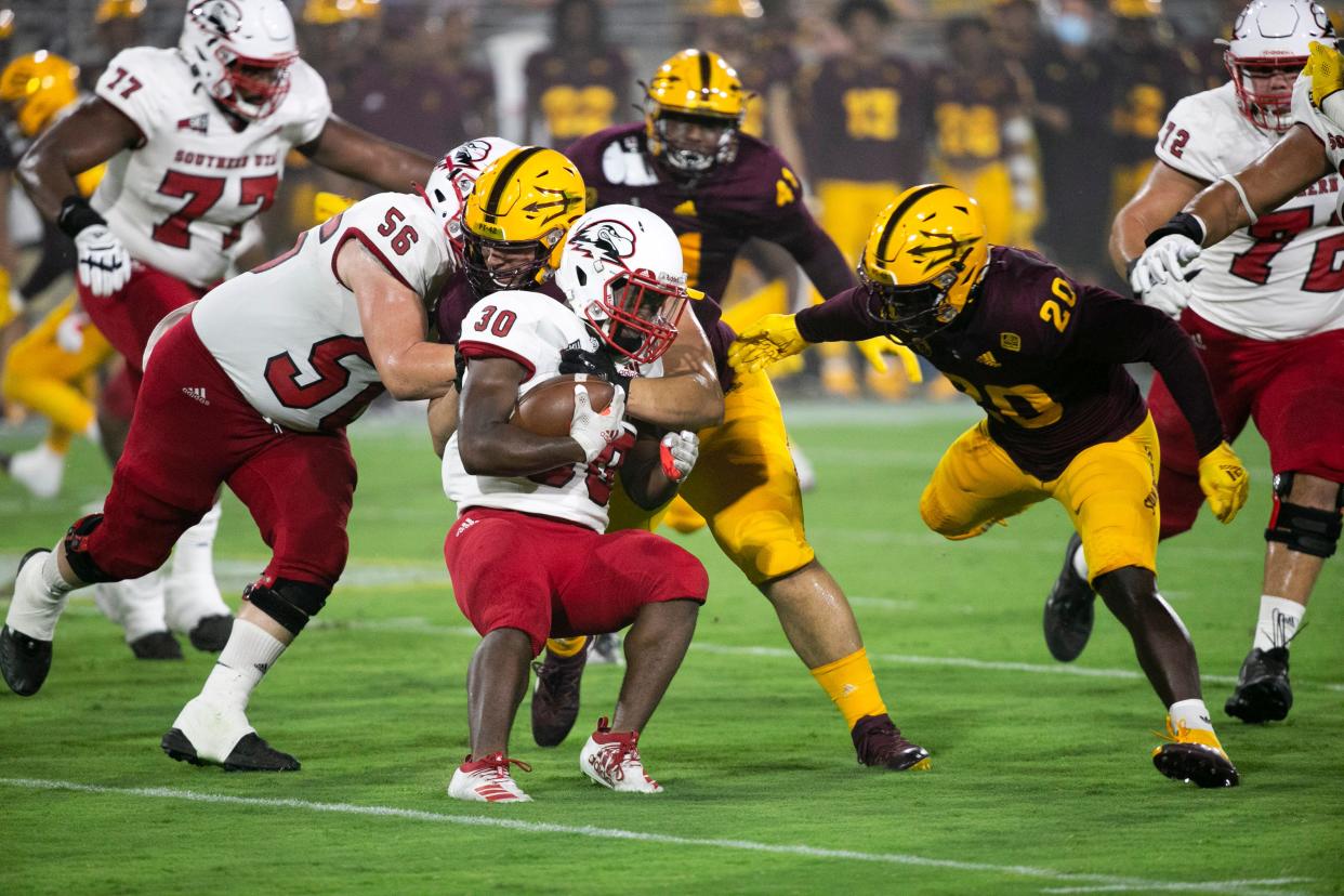 Southern Utah running back David Moore III is tackled by ASU defensive lineman D.J. Davidson, center, and linebacker Darien Butler, right, during the first quarter of the college football game at Sun Devil Stadium in Tempe on September 2, 2021.