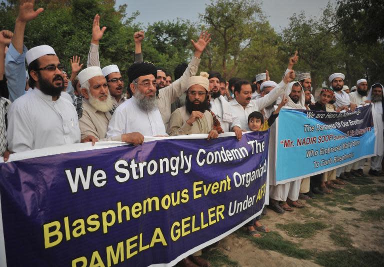 Pakistani residents shout slogans as they march behind a banner during a protest in Peshawar on May 5, 2015, against the anti-Muslim cartoon exhibition in Garland, Texas