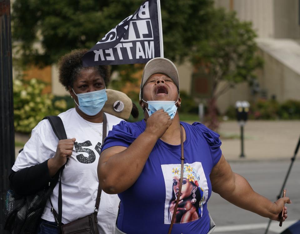 A woman reacts to news in the Breonna Taylor shooting, Wednesday, Sept. 23, 2020, in Louisville, Ky. A grand jury has indicted one officer on criminal charges six months after Taylor was fatally shot by police in Kentucky. The jury presented its decision against fired officer Brett Hankison Wednesday to a judge in Louisville, where the shooting took place. (AP Photo/Darron Cummings)