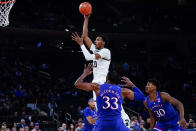Michigan State's Marcus Bingham Jr. (30) shoots over Kansas' David McCormack (33) and Ochai Agbaji (30) during the first half of an NCAA basketball game Tuesday, Nov. 9, 2021, in New York. (AP Photo/Frank Franklin II)