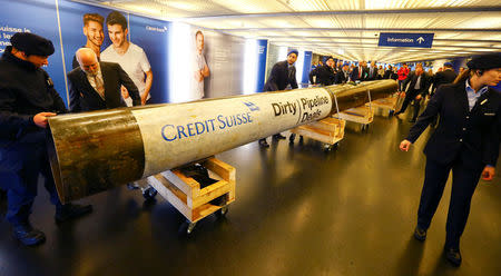 Private security staff stands beside a pipe placed by activists of environmental group Greenpeace to protest against the financing of the Dakota-Access oil pipeline ahead of Swiss bank Credit Suisse's annual shareholder meeting in Zurich, Switzerland April 28, 2017. REUTERS/Arnd Wiegmann