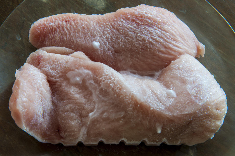 Frozen turkey filet on a brown background.