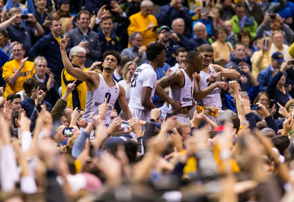 Marquette Golden Eagles players celebrate with fans after their game against the Villanova Wildcats at BMO Harris Bradley Center. The Golden Eagles won 74-72.