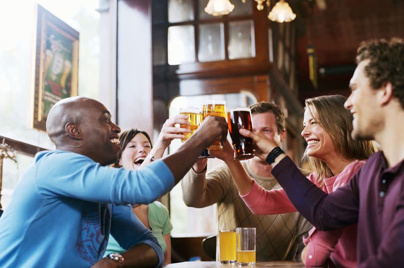 People in pub cheering drinks