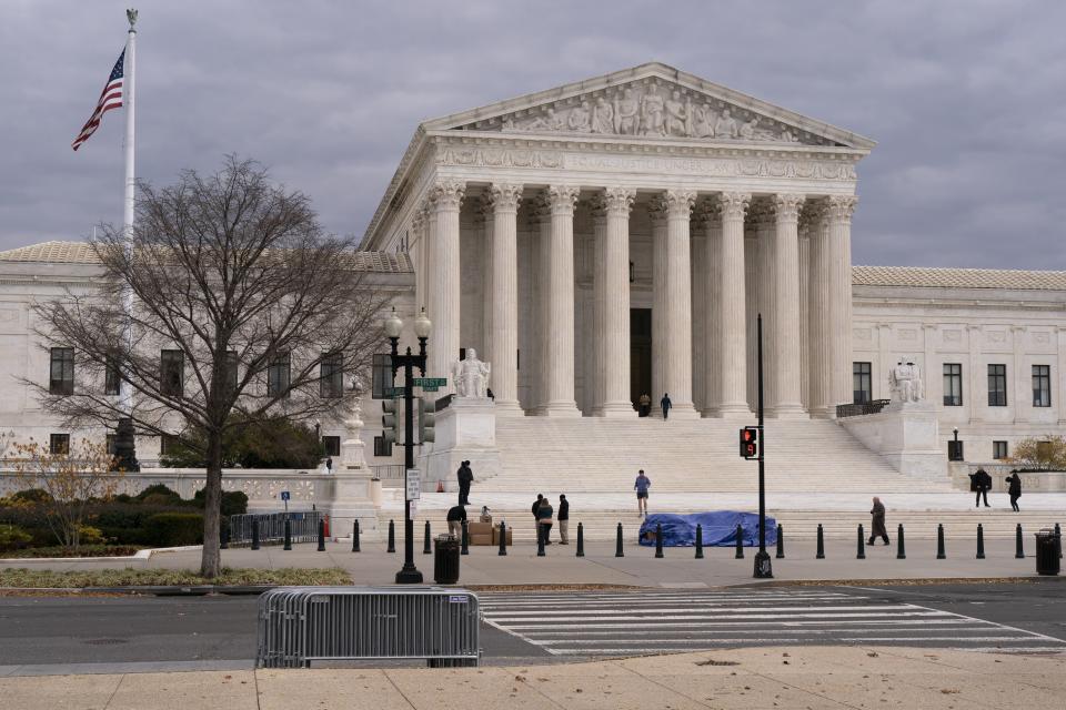 The Supreme Court is seen, Tuesday, Nov. 30, 2021, as activists arrive ahead of arguments on abortion at the court on Capitol Hill in Washington. (AP Photo/Jacquelyn Martin)