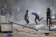 A demonstrators runs amid tear gas smoke during protests against the arrest of opposition leader and former presidential candidate Ousmane Sonko in Dakar, Senegal, Friday, March 5, 2021. Days of violent protests in Senegal have killed at least one person, local reports say, as young people take to the streets nationwide in support of the main opposition leader who was detained Wednesday. (AP Photo/Leo Correa)