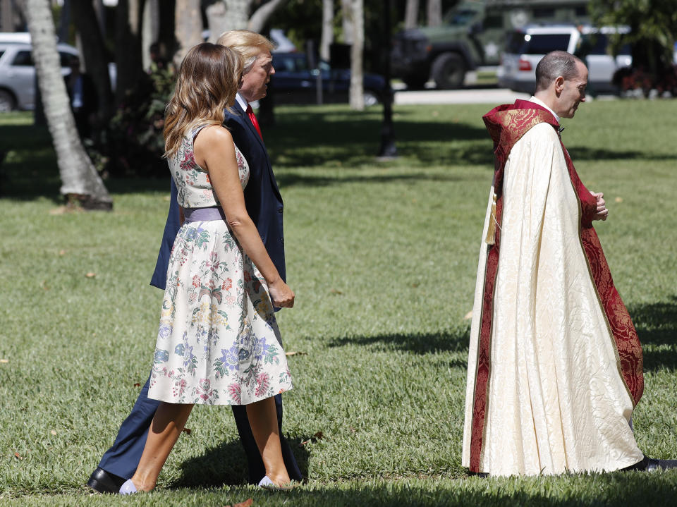 President Donald Trump with first lady Melania Trump, walk behind the Rev. James R. Harlan, right, as they arrive for Easter services at Episcopal Church of Bethesda-by-the-Sea, Sunday, April 21, 2019, in Palm Beach, Fla. (AP Photo/Pablo Martinez Monsivais)