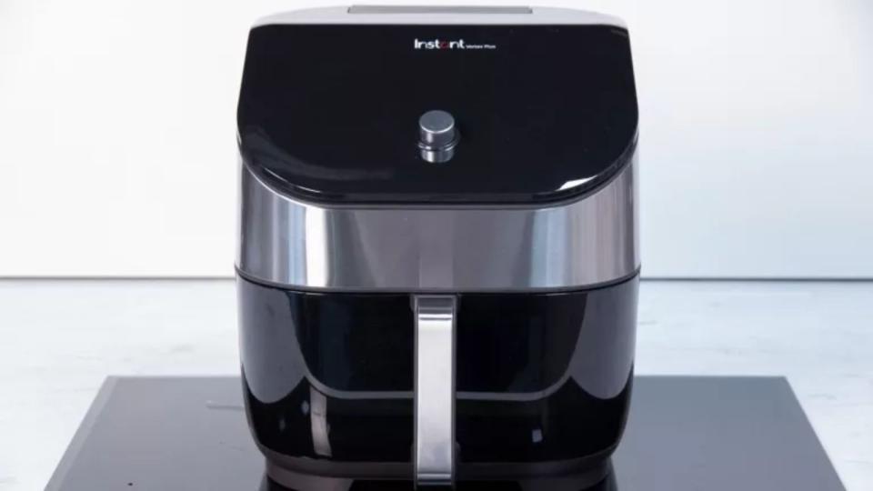 The instant essentials air fryer on a marble countertop