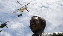 South African military and police helicopters fly past a 9-metre (30-feet) bronze statue of the late former President Nelson Mandela after it was unveiled as part of the Day of Reconciliation Celebrations at the Union Buildings in Pretoria December 16, 2013. The day also marks the commemoration of the centenary of the Union Buildings, one of the most iconic structures in South Africa. The unveiling of the statue is intended as acknowledgement of the contribution of the first president of a democratic South Africa, a symbol of national reconciliation and unity. (REUTERS/Thomas Mukoya)