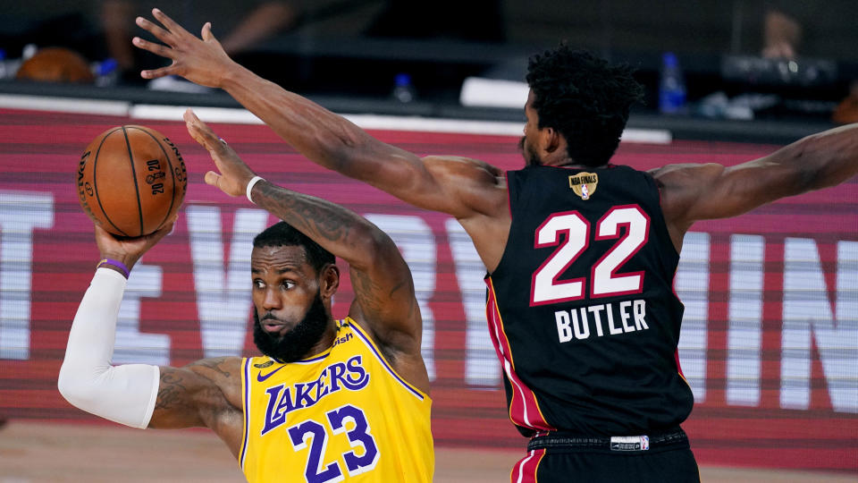 Los Angeles Lakers' LeBron James (23) looks to pass while pressured by Miami Heat's Jimmy Butler (22) during the second half of Game 1 of basketball's NBA Finals Wednesday, Sept. 30, 2020, in Lake Buena Vista, Fla. (AP Photo/Mark J. Terrill)