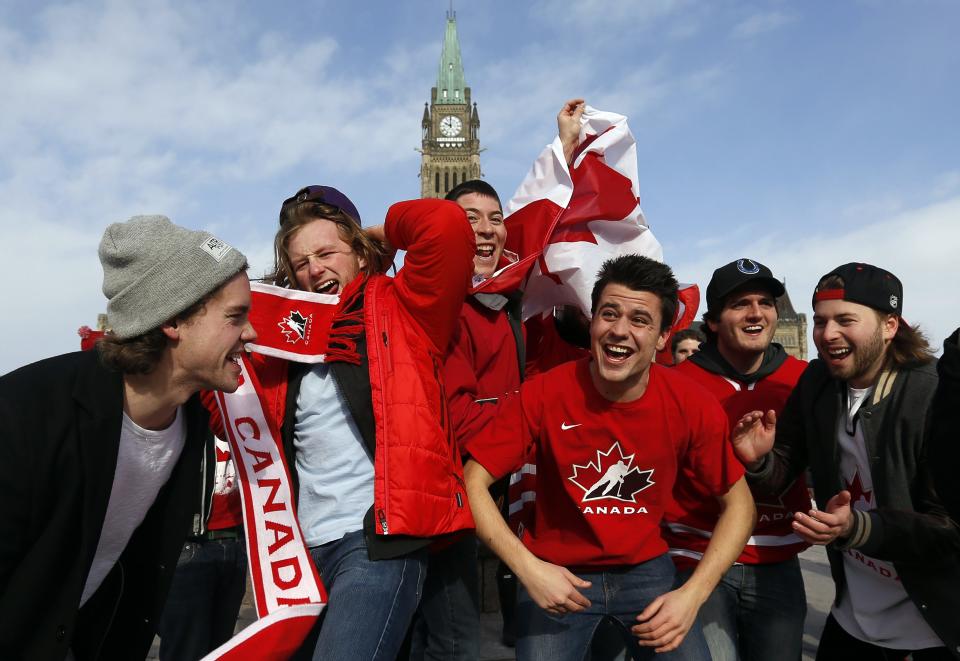 Fans celebrate Canada's gold medal win over Sweden in their men's ice hockey game at the Sochi 2014 Winter Olympic Games, on Parliament Hill in Ottawa February 23, 2014. REUTERS/Chris Wattie (CANADA - Tags: POLITICS SPORT ICE HOCKEY OLYMPICS TPX IMAGES OF THE DAY)